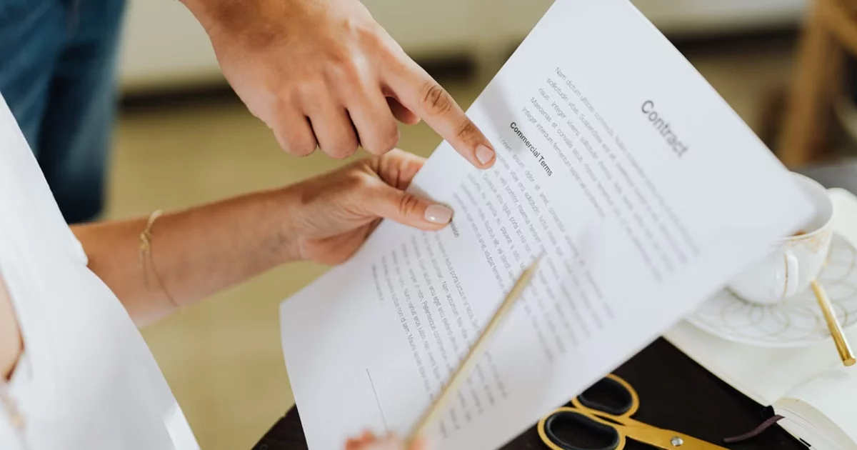 Two people reviewing the commercial terms of a contract, one form of non-dilutive funding